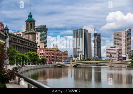 Der klassische Stil General Post Office Gebäude 395 Tiandong Straße Suzhou Creek mit der Sichuan Road Bridge und Wolkenkratzer in den Hintergrund. Stockfoto