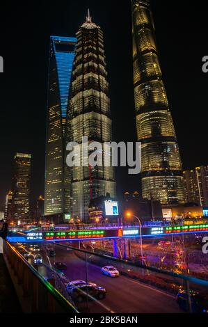 Die Shanghai Tower, Jinmao Tower und Shanghai World Financial Center Wolkenkratzer in der Nacht von den Lujiazui Skywalk gesehen. Stockfoto