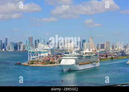 Seefahrer der Meere praktisch leer wie ein Geisterschiff verlässt Hafen von Miami, 28. April 2020 - mit Stadt Miami im Hintergrund und Dodge Island Stockfoto