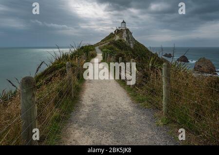 Nugget Point Leuchtturm, Ahuriri flach, Neuseeland - 10. Januar 2020 : der Nugget Point Leuchtturm an einem stimmungsvollen und bewölkten Nachmittag Stockfoto