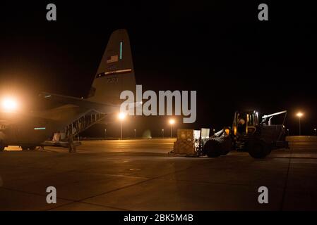 U.S. Air Force Airmen, die dem 75. Expeditionary Airlift Squadron (EAS) zugewiesen sind, beladen einen C-130J Super Hercules mit Ladung in Dschibuti, 27. April 2020. Die 75. EAS bietet strategische Luftauftriebsfähigkeiten im gesamten Zuständigkeitsbereich der gemeinsamen Task Force Horn von Afrika (CJTF-HOA) und ist für die Verlegung vieler medizinischer Versorgungsmaterialien in Außenstationen im Rahmen der COVID-19-Pandemiereaktion verantwortlich. (USA Air Force Foto von Tech. Sgt. Ashley Nicole Taylor) Stockfoto