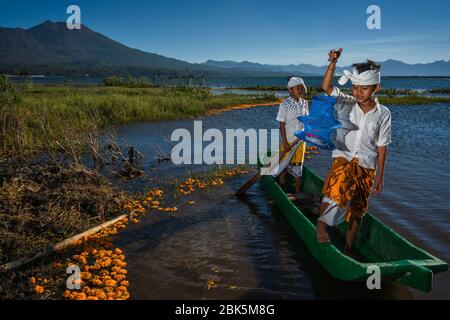 Lake Batur, Kintamani, Bangli, Bali, Indonesien - 28. Juni 2019 : der Versuch, einen Fisch von zwei balinesischen Jungen in traditionellem Outfit auf dem Lake Batur zu fangen Stockfoto