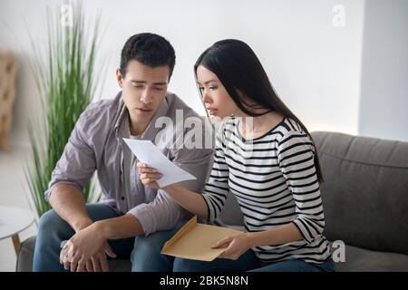 Junge Frau und Mann lesen ein offenes Dokument. Stockfoto