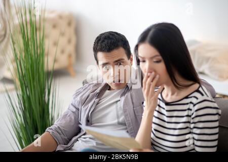 Überrascht junge Frau und Mann ein Dokument lesen. Stockfoto