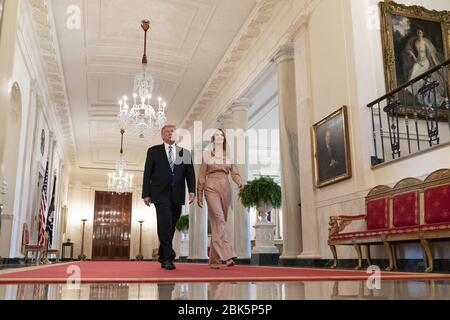 Washington, Vereinigte Staaten Von Amerika. April 2020. Präsident Donald J. Trump und Beraterin von Präsident Ivanka Trump gehen am Dienstag, den 28. April 2020, entlang der Kreuzhalle des Weißen Hauses, um an einer Veranstaltung im Ostraum über das Paycheck Protection Program und seine Unterstützung kleiner Unternehmen während der Coronavirus-Pandemie teilzunehmen. Personen: Präsident Donald Trump, Ivanka Trump Kredit: Storms Media Group/Alamy Live News Stockfoto
