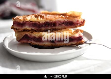 Ein Stück Kirschkuchen auf einem weißen Teller servieren/ Nahaufnahme Stillleben Food Fotografie Stockfoto