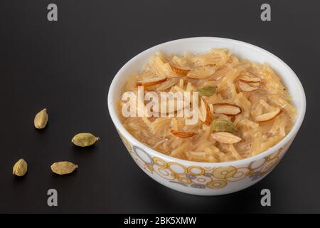 Nudeln Dessert, beliebte Süßspeise wissen eine kheer mit Milch und garnieren Sie es mit trockenen Früchte auf schwarzem Hintergrund grau isoliert, die in der Schüssel serviert. Sele Stockfoto