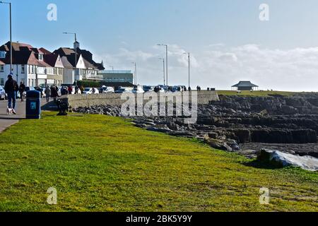 Die Promenade in Porthcawl mit Häusern mit Blick auf das Meer. Bei Ebbe wird das felsige Vorland mit nur einem kleinen Sandbereich aufgedeckt. Stockfoto