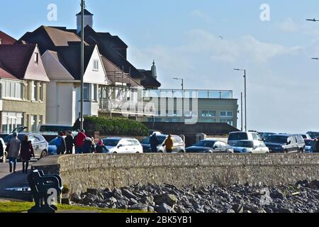 Die Promenade in Porthcawl mit Häusern mit Blick auf das Meer. Bei Ebbe wird das felsige Vorland mit nur einem kleinen Sandbereich aufgedeckt. Stockfoto