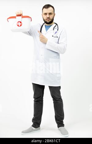 Junge bärtige Sanitäter mit rotem Kreuz medizinisches Kit zeigt mit Zeigefinger Stockfoto