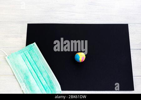 Handgemachtes Kunsthandwerk. Kreative Aktivitäten für Kinder im Urlaub und in Quarantäne. Schwarzes Papier und Neon-Plastilin. Maske zum Schutz gegen die viru Stockfoto