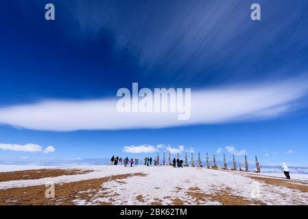 Baikalsee, Russland - 11. März 2020: Rituelle Säulen am Kap Burkhan auf der Insel Olchon mit wunderschönem Himmel, Wolken und Menschen Stockfoto