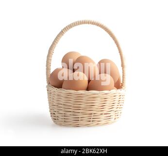 Eier im Weidenkorb auf weißem Hintergrund mit Schnittwegen isoliert Stockfoto