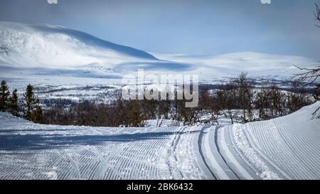 Skilanglauf. Leere Tourenskiroute. Schneebedeckte Berge im Hintergrund. Stockfoto