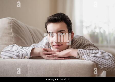 Teenager junger Mann auf dem Sofa zu Hause liegen Stockfoto