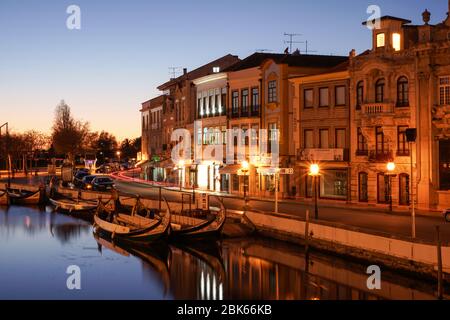 Traditionelle Moliceiro Boote spiegeln sich bei Einbruch der Dunkelheit im Hauptkanal. Stockfoto