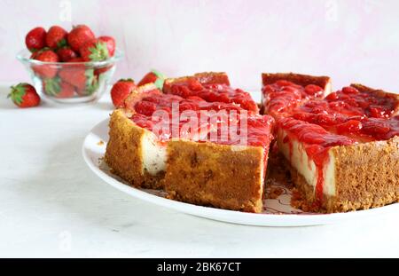 Hausgemachtes Backkonzept. Scheiben Erdbeerkäsekuchen auf weißem Hintergrund. Nahaufnahme. Stockfoto