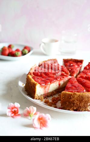 Hausgemachtes Backkonzept. Scheiben Erdbeerkäsekuchen auf weißem Hintergrund. Nahaufnahme. Stockfoto