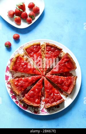 Hausgemachtes Backen. Erdbeerkäsekuchen auf blauem Hintergrund. Draufsicht. Stockfoto