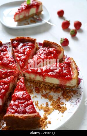 Hausgemachtes Backkonzept. Scheiben Erdbeerkäsekuchen auf weißem Hintergrund. Nahaufnahme. Stockfoto