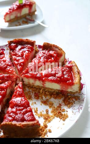 Hausgemachtes Backkonzept. Scheiben Erdbeerkäsekuchen auf weißem Hintergrund. Nahaufnahme. Stockfoto