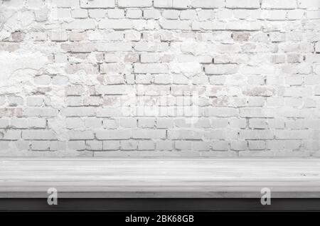 Leerer weißer Holztisch und raue Ziegelwand Stockfoto