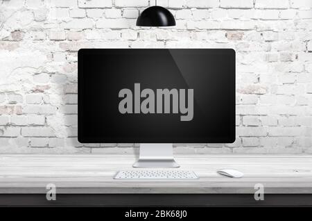 Computerdisplay Mockup auf Holzschreibtisch mit Ziegelwand im Hintergrund und schwarzer Lampe auf der Oberseite Stockfoto