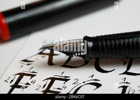 Viersen, Deutschland - April 30. 2020: Handschriften und Kalligraphie Lernkonzept: Makro Nahaufnahme von Tintenstift und Kalligraphie handgeschriebenen Alphabet Buchstaben Stockfoto