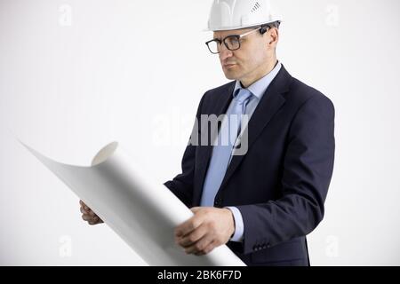 Portrait des Architekten Baumeister in Schutzhelm Studium Layout-Plan Stockfoto