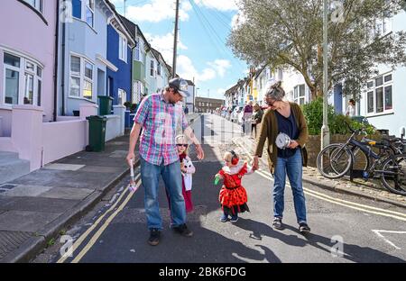 Brighton UK 2. Mai 2020 - Kinder von Familien in der Elm Grove Gegend von Brighton beschlossen, sich zu verkleiden und sich heute Morgen kurz auf ihre Straße zu machen, um soziale Distanz zu beobachten an dem Tag, an dem es die Brighton Festival Kinderparade während der Coronavirus COVID-19 Pandemie gewesen wäre Krise . Die Kinderparade ist der traditionelle Auftakt zum jährlichen Brighton Festival, das dieses Jahr aufgrund des Coronavirus abgesagt wurde. Quelle: Simon Dack / Alamy Live News Stockfoto