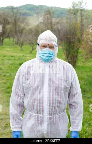 Porträt des älteren Mannes trägt Hasmat Anzug, Maske und Handschuhe im Freien - covid-19 Pandemie Stockfoto
