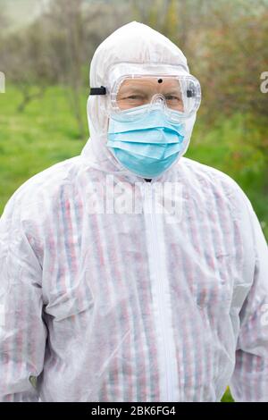 Porträt des älteren Mannes trägt Hasmat Anzug, Maske und Handschuhe im Freien - covid-19 Pandemie Stockfoto