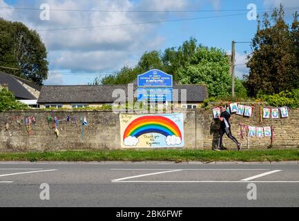 Chippenham, Wiltshire, Großbritannien, 2. Mai 2020. Eine Person, die läuft, wird abgebildet, als sie an den Schildern „Danke NHS“ und „Danke an alle wichtigen Arbeiter“ vorbeilaufen, die an einer Wand der Grundschule gegenüber dem Chippenham Hospital angebracht wurden. Kredit: Lynchpics/Alamy Live News Stockfoto