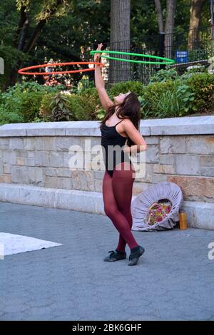 Ein Straßenkünstler-Busker, der tanzt, während er Hula Hoops dreht. Im Union Square Park in Manhattan. Stockfoto
