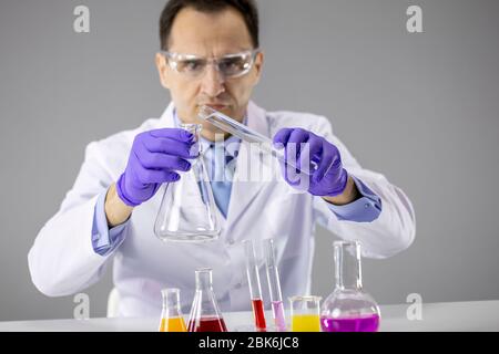 Laborbegleiter, der im Labor mit Reaktionsröhrchen arbeitet und wissenschaftliche Experimente durchführt Stockfoto