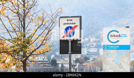 Como, Italien - 4. November 2017: Straßenschild Ende der Fußgängerzone in Italienisch (Bereich pedonale) neben einer Bike-Sharing-Station Bike & Co im Stadtzentrum Stockfoto