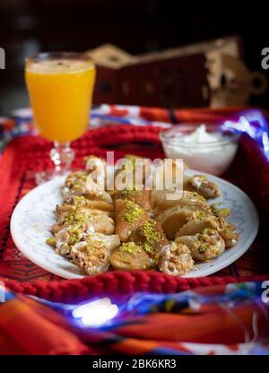 Orientalisches Dessert genannt Atayef mit Nüssen und orientalischem Getränk genannt Amar el-din, die speziell im heiligen Monat des Ramadan gebildet werden Stockfoto