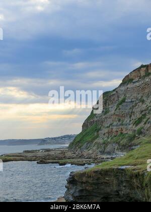 Sonnenstrahlen brechen durch die Wolken, Newcastle Cliffs, Australien Stockfoto