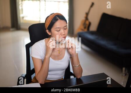 Frau, die von zu Hause aus in einem improvisierten Büro im Wohnzimmer arbeitet Stockfoto