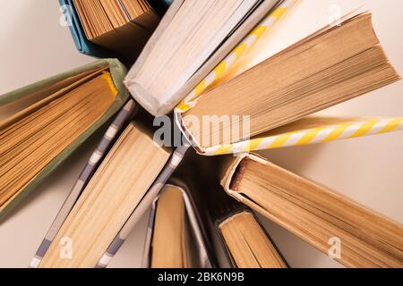 Flaches Layout von mehreren Büchern in Papierhüllen auf weißem Schreibtisch, die als Hintergrund für Schule oder Bildungsfach verwendet werden kann Stockfoto