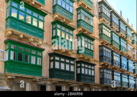 Reihe von bunten Balkonen auf Häusern in einer Straße in Valletta, malta. Stockfoto