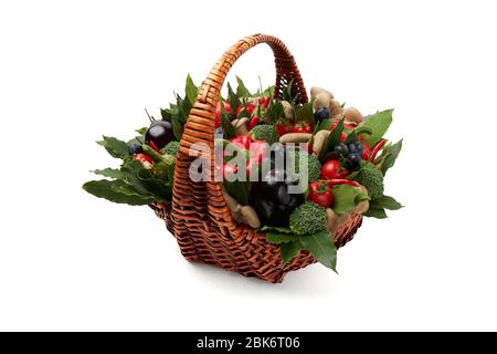 Weidenkorb gefüllt mit verschiedenen frischen reifen Gemüse auf weißem Hintergrund. Stockfoto