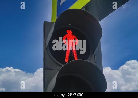 Ampel mit einem brennenden roten Signal. Ampel mit brennendem roten Licht auf einem Hintergrund mit wolkig blauem Himmel. Stockfoto