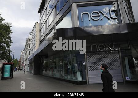 London, Großbritannien. Mai 2020. Das Foto vom 1. Mai 2020 zeigt einen Mann, der an dem geschlossenen Next Store in der Oxford Street in London vorbeigeht. Der britische Modehändler Next on Wednesday meldete einen Umsatzeinbruch in seinem ersten Geschäftsquartal (Q1), das am 25. April endete, als das Unternehmen seine Lager- und Vertriebsnetze aufgrund des neuartigen Coronavirus-Ausbruchs vorübergehend schloss. Kredit: Tim Ireland/Xinhua/Alamy Live News Stockfoto