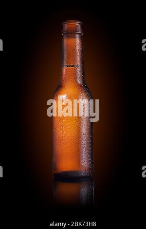 Braune kleine Flasche voll Flüssigkeit mit Tropfen auf schwarzem Hintergrund Stockfoto