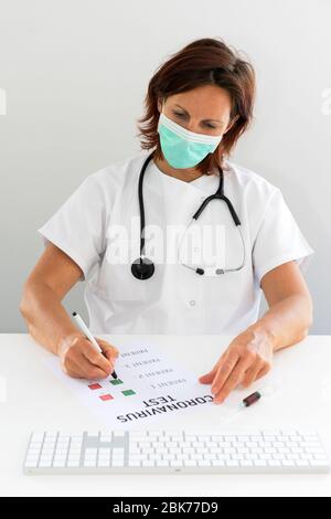 Frau Arzt schriftlich auf Coronavirus Testliste Stockfoto