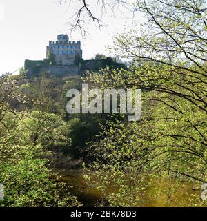 Burg Pyrmont auf einem Hügel, umgeben von grünen Bäumen an einem Frühlingstag in Deutschland. Stockfoto