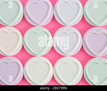Blank Love Hearts Süßigkeiten und Süßigkeiten in Reihen mit Platz für Kopie Raum in einem romantischen Hintergrund ausgelegt Stockfoto