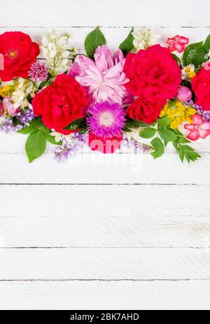 Blumenarrangement Rand von verschiedenen wilden und Gartenblumen aus Rosen, Pfingstrosen und Jasmin auf einem weißen Holzhintergrund mit Kopierraum, Draufsicht Stockfoto