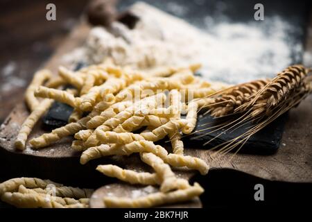 Rohe Pasta busiate auf Holztisch Nahaufnahme Stockfoto